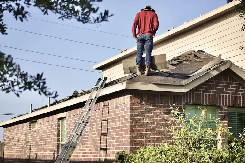 Professional roofer working on a residential roof in Dolly Varden